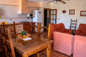 a kitchen and dining room with a wooden table and chairs at Casa Rural La Escuela Caravaca in Caravaca de la Cruz
