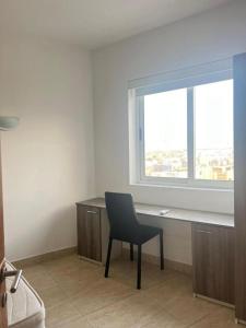 a desk and a chair in a room with a window at Giotto - Room 1 in Msida +3 photos