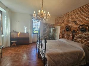 a bedroom with a bed and a brick wall at Villa Lago Groundfloor Lakefront Beach Garden Bike&Boat& Scooter Lake Como in Colico