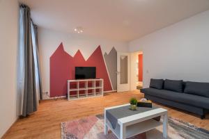 a living room with a couch and a tv at In 2 Minuten am Bahnhof - traumhaftes Apartment mitten in Halle No3 in Halle an der Saale