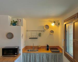 a kitchen with a sink and a microwave at Trulli Milena in Putignano