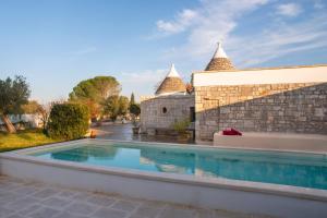 a villa with a swimming pool and a building at Trulli Milena in Putignano