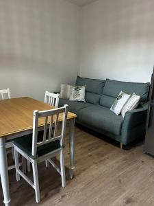 a living room with a green couch and a table at Via De'Amicis in Certaldo