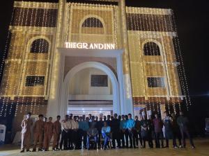 a group of people standing in front of a building at The Grand Inn Resort in Dum Duma