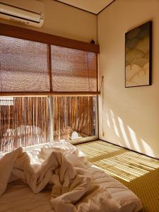a bedroom with a bed in front of a window at Leisureyado 悦宿 USJ 西九条 in Osaka