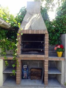 einen Backsteinofen mit Blumen im Garten in der Unterkunft Gran chalet con jardín, piscina y BBQ in Sada