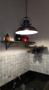 a light hanging over a sink in a kitchen at Casa Magdeburg I - Central e Aconchegante in Pomerode
