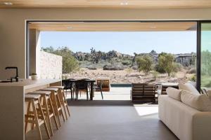 a living room with a couch and a table and chairs at Ren House Luxury Nature Retreat in Yucca Valley