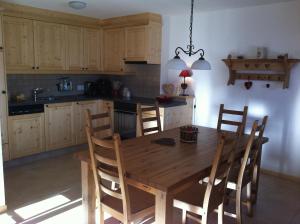 a kitchen with a wooden dining table and chairs at Thyon 4pièces, proche des pistes in Hérémence