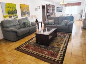 ein Wohnzimmer mit zwei Sofas und einem Couchtisch in der Unterkunft Gran chalet con jardín, piscina y BBQ in Sada