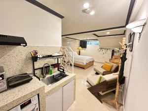 a kitchen with a sink and a living room with a couch at CozyNook Boutique Apartments - 3 thang 2 Street in Da Lat