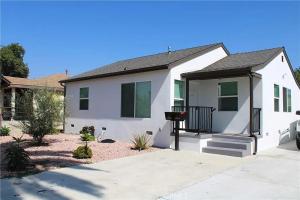 a white house with a porch and a driveway at Single family house in Long Beach