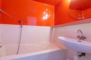 a bathroom with a sink and an orange wall at Studio charmant à Bourg-Saint-Maurice avec balcon et vue in Bourg-Saint-Maurice +12 photos