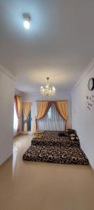 a bedroom with a large bed with a chandelier at Villa Highland No 8 UU Berastagi View in Berastagi