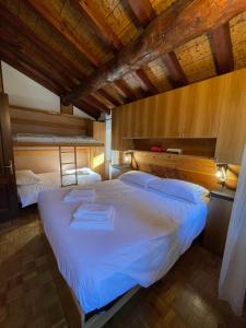 a bedroom with two beds in a room with wooden ceilings at La Maison del Bon Grato in Champorcher