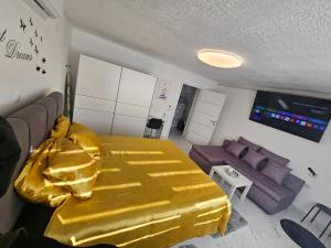 a bedroom with a yellow bed and a couch at ENA 1&2 apartments-free parking 2200 m2-truck,trailer,boats friendly-EASY D1 access in Karlovac