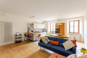 a living room with a blue couch and a kitchen at A Casa di Silvia in Recanati