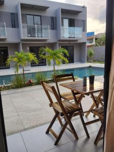 a patio with a table and chairs next to a swimming pool at Flat 1501 na ilha de Itamaracá in Itamaracá +20 photos