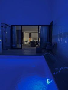 a swimming pool in a house with a blue light at فندق نارس البخاري in Buraydah