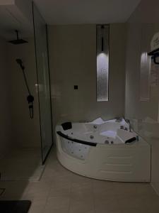 a white bath tub in a bathroom with a shower at فندق نارس البخاري in Buraydah +42 photos