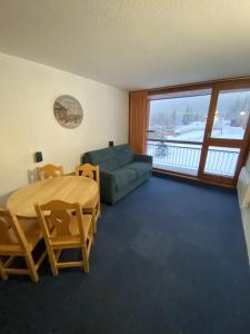 a living room with a table and a couch at Studio charmant à Bourg-Saint-Maurice avec balcon et vue in Bourg-Saint-Maurice