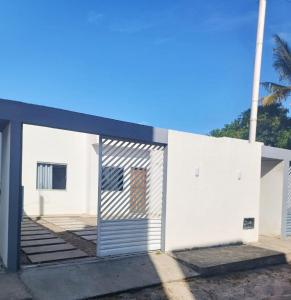 a white building with a door on the side at Ambiente Familiar e Próx a Tudo! in Prado