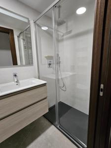 グラナダにあるHabitación independienteのガラスのシャワーと洗面台を備えたバスルーム