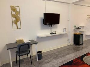 a room with a desk and a tv on the wall at Mana restaurant & boutique hotel in Ban Si Than