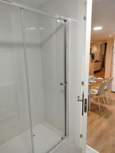 - une porte de douche en verre dans une chambre avec une table dans l'établissement ESTUDIOS 55 - - CÉNTRICO - RH Santander, à Santander