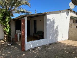 une petite maison blanche avec une porte ouverte dans l'établissement Casa en Costa Azul - Rocha - Frente al mar, à La Paloma