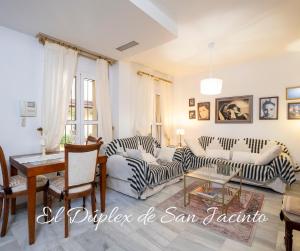 un soggiorno con due divani e un tavolo di El Dúplex de San Jacinto a Siviglia Altre 50 foto