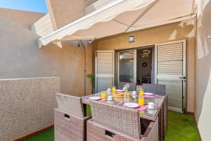 Una mesa con sillas y comida en un patio. en MEDANO4YOU Sunrise Medano, en El Médano