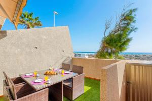 Una mesa con platos de comida encima de un patio. en MEDANO4YOU Sunrise Medano, en El Médano
