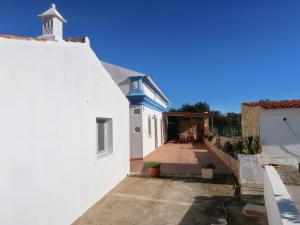 a white house with a porch and a white wall at Ferienhaus Quinta dos Arvores by fewo-plan ESTO102 an der Algarve in Azinheiro