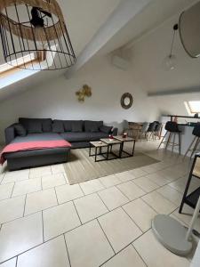 ein Wohnzimmer mit Sofa und Tisch in der Unterkunft Atelier Voyageur in Chartres