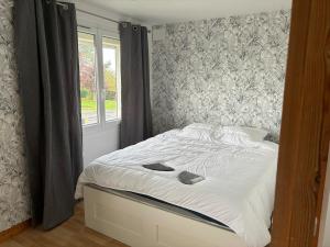 a bedroom with a large bed with a window at La Gravelinoise in Gravelines