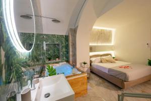卡塔尼亚ETNEA 208 LUXURY JACUZZI SUITE Catania的带浴缸、床和水槽的浴室