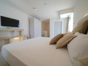 a bedroom with a white bed with two pillows on it at HOTEL BARONE DI MARE in Torre dell'Orso