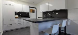 a kitchen with white cabinets and a black counter top at Ferienwohnung Eisgeliebt in Schweinfurt