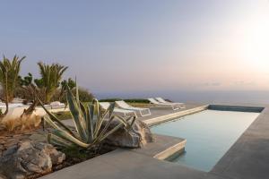a swimming pool with chairs and a view of the ocean at Villa Kea in Kastrianí