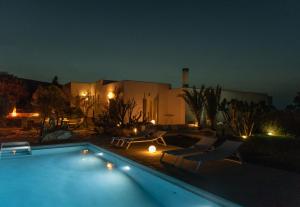 a swimming pool in front of a house at night at Villa Kea in Kastrianí