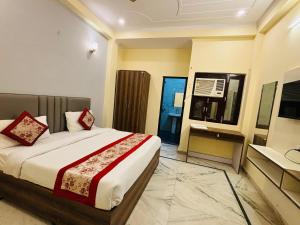 een slaapkamer met een bed en een bureau erin bij Hotel Vegas Corporate Suites By Aura in Noida