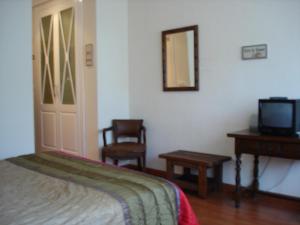 a bedroom with a bed and a television and a table at Tierra de Campos in Osorno