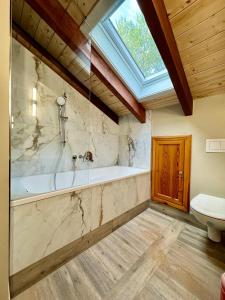 a bathroom with a tub and a toilet and a window at Haus Elim für Gruppen und Großfamilien in Heringsdorf
