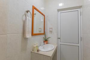 un bagno bianco con lavandino e specchio di Nemo Inn a Omadhoo