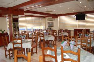 ein Restaurant mit Tischen und Stühlen in einem Raum in der Unterkunft Motel Maestro in Deva
