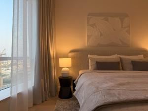 a bedroom with a bed with a lamp and a window at Signature Studio JLT in Dubai +5 photos