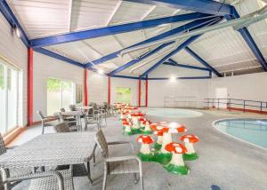 a room with tables and chairs and a swimming pool at Hideaway Ribble Valley in Preston