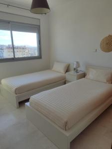a bedroom with two beds and a window at Seaview Tanger Apartment in Tangier