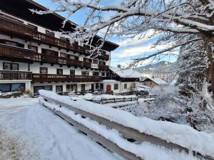 a fence covered in snow in front of a building at Apartment Peacock - Steinbock Lodges in Zell am See